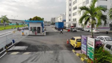 İşçiler ve yayalar araç geçerken binanın içinde ve dışında yürüyorlar.