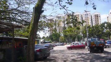 Mavi gökyüzü ve arkada arabalı bir bina.