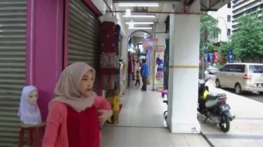 Mavi gömlekli bir adam yürüyor.