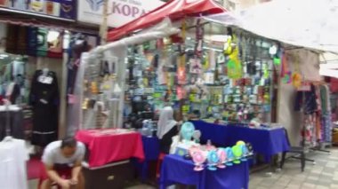 Adam dükkânın yanına oturmuş bakıyor.