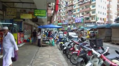 İnsanlar bir sıra motosikletin yanından geçiyorlar.