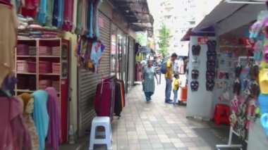 İnsanlar ellerinde bir çantayla bir mağazanın etrafında yürüyorlar.