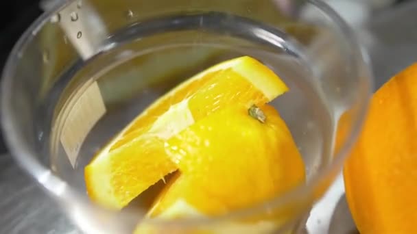 Pomarańczowe Plastry Wewnątrz Szklanki Wody — Wideo stockowe