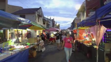 İnsanlar kabinlerin arasında yürüyorlar.