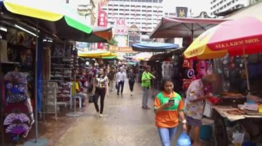 Bir sürü insan tezgahların arasında yürüyor.