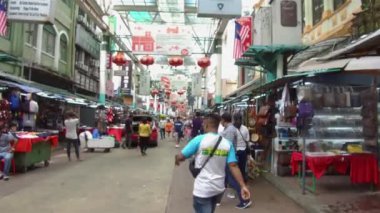 Bir sürü insan tezgahlarla yolda yürüyor.