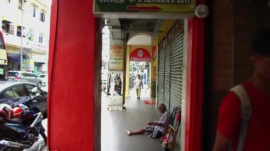  İnsanlar bir mağazanın önünde yerde oturuyorlar..