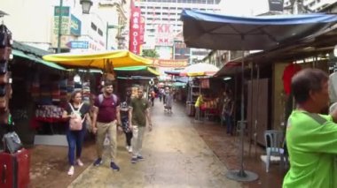 İnsanlar tezgahın yanında dikilirken diğerleri yürür