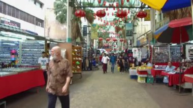 İnsanlar pazarda dükkanlarıyla dolaşıyorlar.