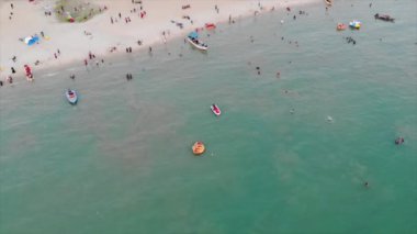 Kum üzerinde insanlar olan deniz manzarası