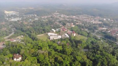 Kuala Lipis 'te renkli çatıları olan küçük binaları çevreleyen yeşil ağaçlar