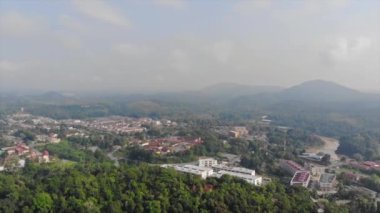 View Of The Mountains With Thick Jungles And Small Houses - Aerial Shot Pan Right To Left