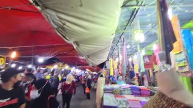 Covid-19 salgını sırasında insanlar gece pazarında maske takıyor.