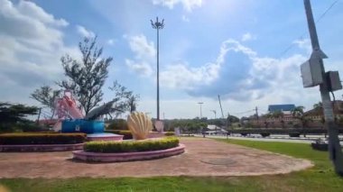 Soldan sağa güneşli bir öğleden sonra tepsisinde Malezya okulunun karşısındaki sanat kurulumu.