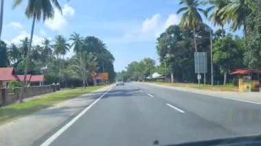 Malezya 'nın kırsal kesiminde güneşli bir günde İki Taraflı Cadde' de Araba Kullanmak.