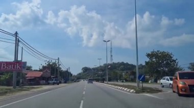 Yol kenarındaki yemyeşil ağaçların arasında telefon kulesi