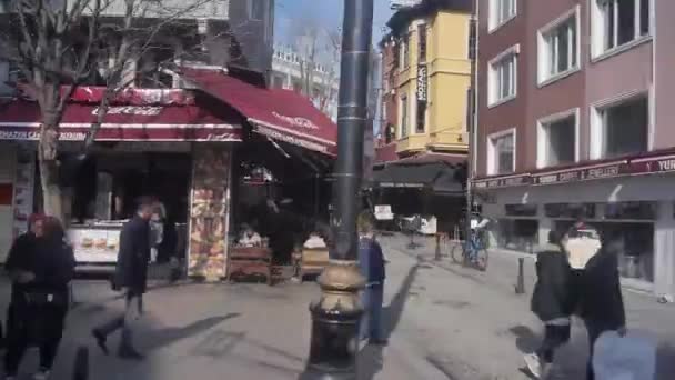 路面電車の窓から見る街のお店や通りを歩く人たちのすれ違い スライド 左から右へ — ストック動画
