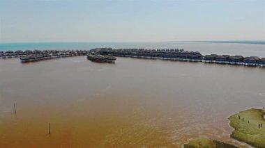 Sepang Malezya 'da okyanus suyunun üzerinde duran evler soldan sağa doğru dönüyor..