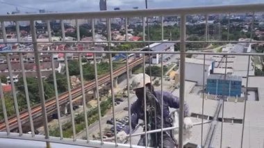  Miğferli adam apartmanın duvarını boyuyor. 