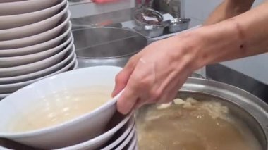 Çorbanın içinde pişirilmiş erişteler yemek çubukları tarafından toplanıp kaseye konuldu..