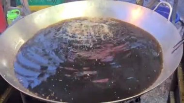 Çin usulü kızarmış ekmek yapmak için yağla doldurulmuş dev bir çömleğe atılmış ekmek hamuru.