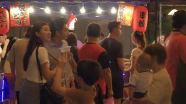 Kalabalık yemek standının yanında yürüyen çift.