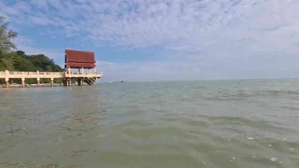 在炎热的夏天 在海滩的尽头 有一个红色的小船顶的海洋码头 — 图库视频影像