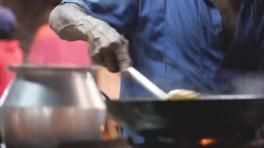 Konuşurken yemek karıştıran Hintli adam.