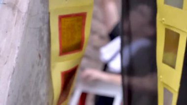 Genç Çinli Adam madalya takmak için merdiven kullanıyor.