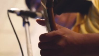  Performans sırasında gitar çalarken Asyalı Adam Şarkı Söylüyor.