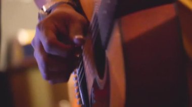 Performans sırasında Asyalı Adamın Parmakları Gitarda Çırpınıyor