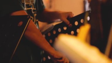 Asyalı Adamın Elleri Müzik Standı Hazırlıyor