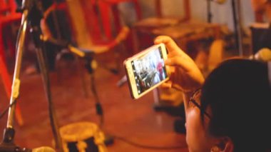 Cep telefonuyla kaydedilen gözlüklü genç Asyalı kadın