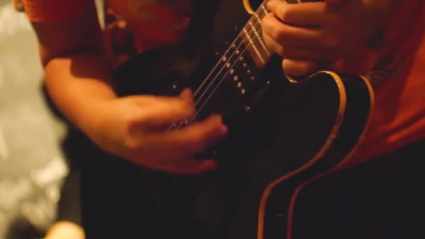 低キーライティングでギターを弾く若いアジアの女性 — ストック動画