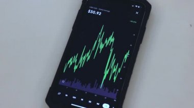 LINK 1 Month chart on a black phone placed on a table