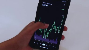 Woman looking through DOT 1 Day chart on Black smartphone