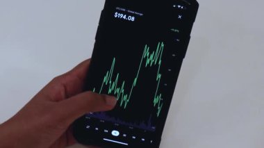 Woman looking through LTC 1 Day chart on Black smartphone