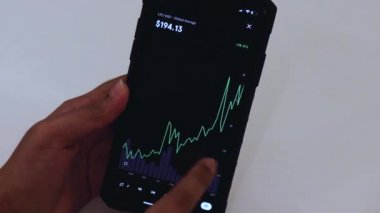 Woman looking through LTC 3 Years chart on Black smartphone