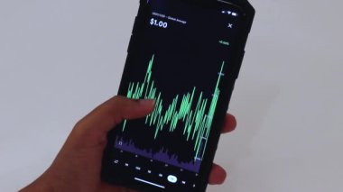 Woman looking through USDT 1 Week chart on Black smartphone