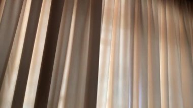 Güneşin soldan sağa doğru parladığı büyük kapalı perdeler.