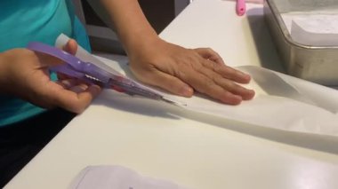  Kadın pasta tepsisine sığmak için kağıt kesiyor. 