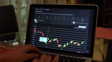 Woman going through XRP 7 days Candle Stick Charts on a Laptop