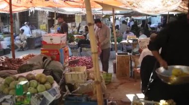 Erson eski bir makinede meyve tartıyor.