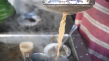 Karaçi 'deki geleneksel tezgahta bir fincana çay döküyorum.