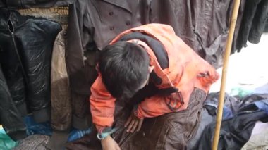 Çocuk kahverengi ceketi kontrol ediyor..