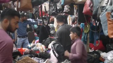 Küçük çocuk tezgahta çanta satıyor..