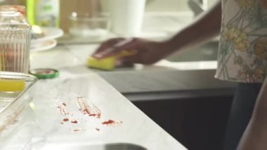 Afrikalı kadın mutfağı süngerle temizliyor.