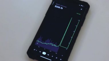 BNB 3 Months chart on a black phone placed on a table