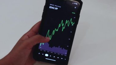 Woman looking through Binance coin charts on phone