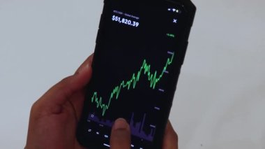 Woman looking through Bitcoin 1 Day chart on Black smartphone